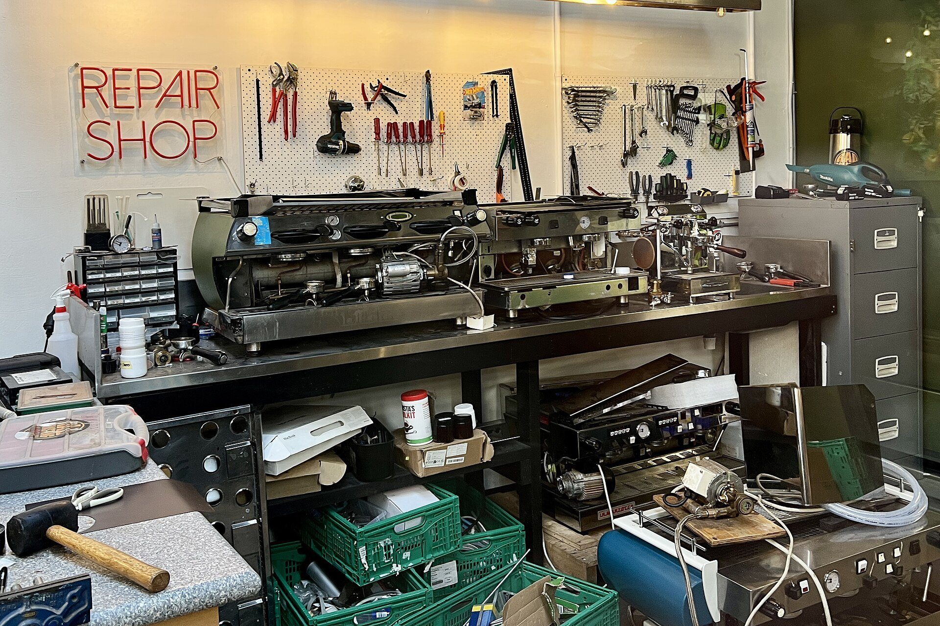Officina di riparazione con macchine da caffè professionali e attrezzi